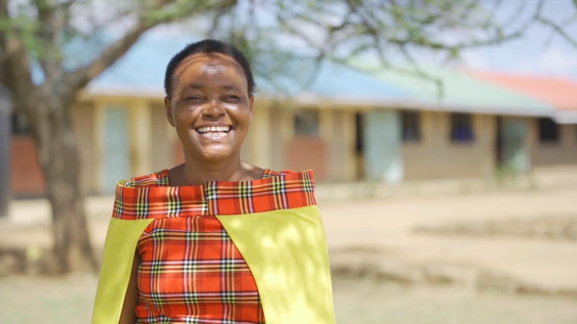 Headteacher Silole stands in front of her school where she secured food for her students